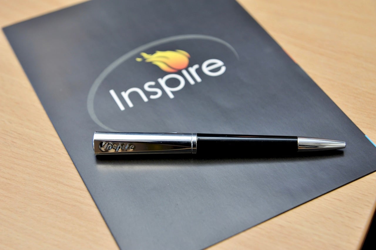 pen on a brochure that says "inspire".