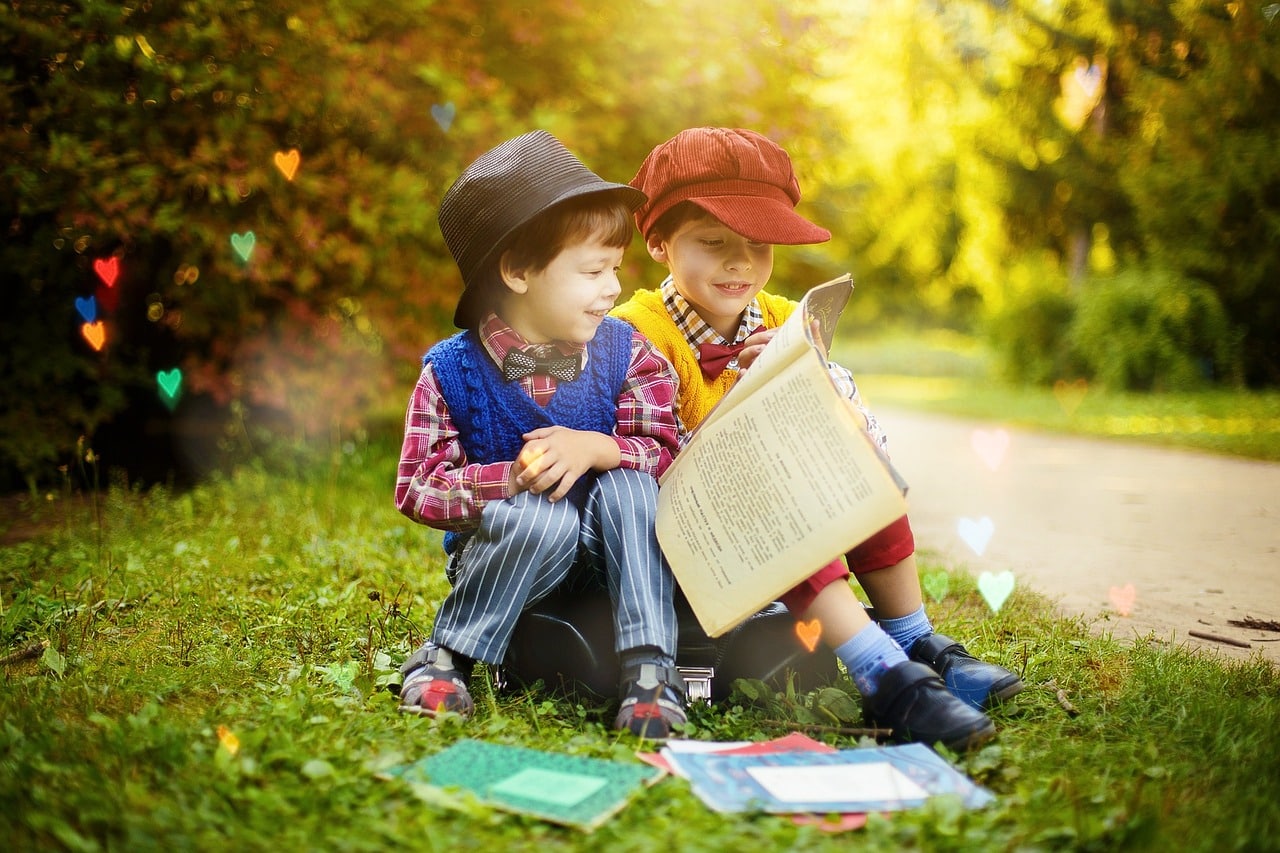 two children enjoying a book in the garden